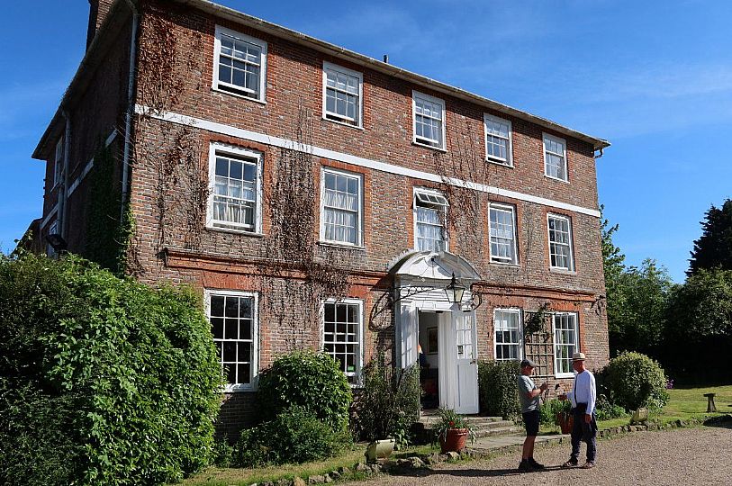 The front of Kench Hill house, with two men stood chatting in front